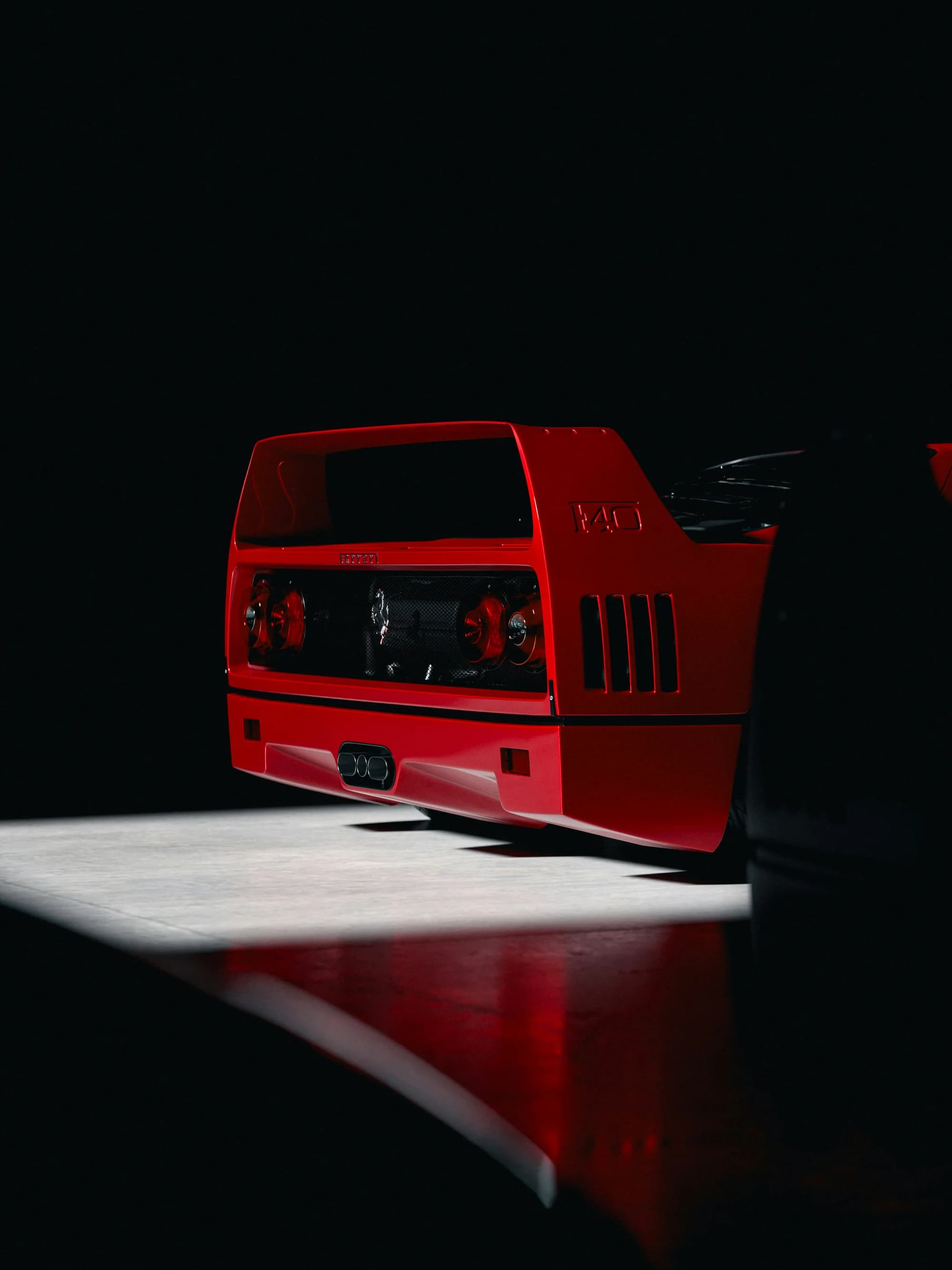 Ferrari F40 rear three-quarter in dramatic studio light